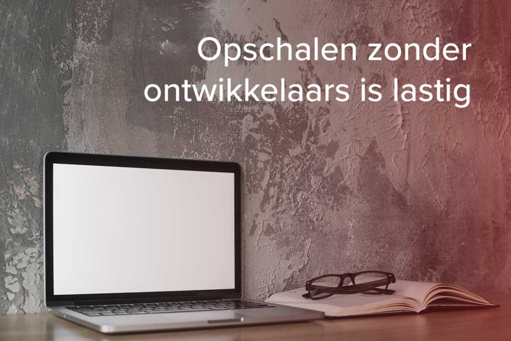 Opschalen zonder ontwikkelaars is moeilijk. Leeg bureau met laptop